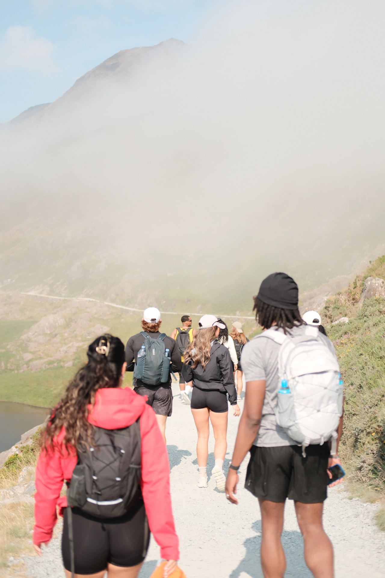 A group of friends hiking together along a misty mountain trail