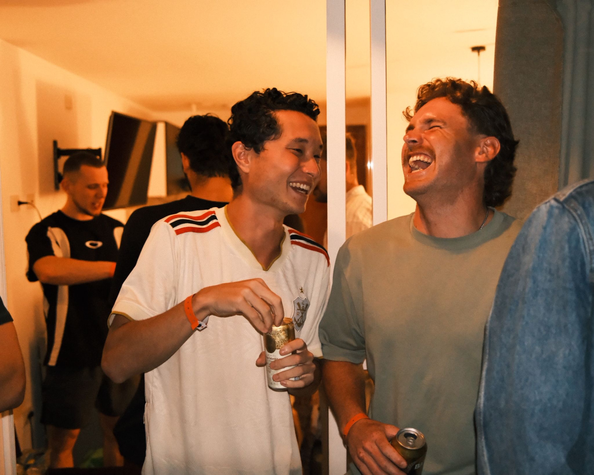 Two friends laughing together over a drink